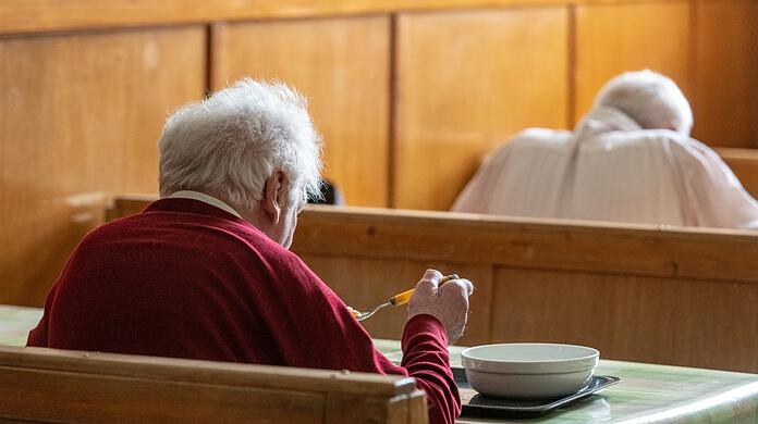 Zwei Senioren sitzen beim Essen in der Fürstlichen Notstandsküche im Schloss St. Emmeram in Regensburg. Dort werden bedürftige Menschen mit einem warmen Mittagessen versorgt. Sehr viele Menschen in Bayern erhalten eine Rente unterhalb der Armutsgefährdungsschwelle.