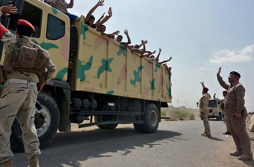 Winkend in den Kampf: Schiitische Freiwillige werden mit Militär-Lastwagen in den Kampf gegen die sunnitischen Isis-Milizen gefahren.