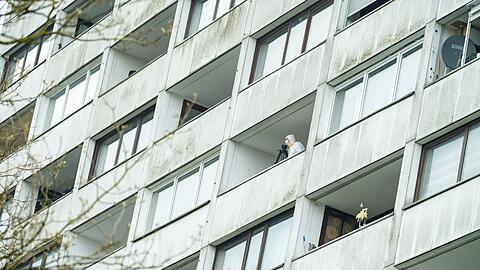 Ermittler untersuchen einen Balkon des Hochhauses.