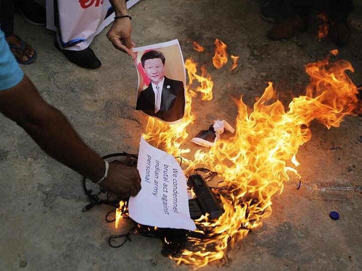 Auf einer Straße im indischen Ahmedabad wird ein Foto des chinesischen Präsidenten Xi Jinping verbrannt.