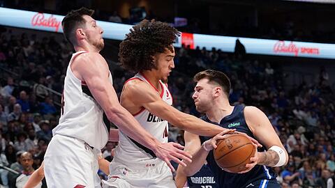 Portlands Drew Eubanks (l) und CJ Elleby (M) verteidigen gegen Luka Doncic von den Dallas Mavericks.
