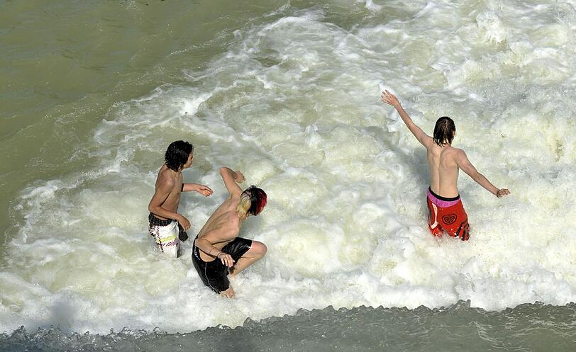 Riesengroßes &ndash; und sogar erlaubtes &ndash; Badevergnügen in der Isar: Die drei Buben tollen am Flaucher im Wasser &ndash; also an einem von vier freigegebenen Bereichen im Stadtgebiet.