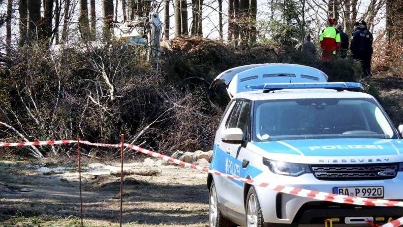 Polizeibeamte durchsuchen eine Fläche an einem Waldrand bei Flossenbürg. Foto: