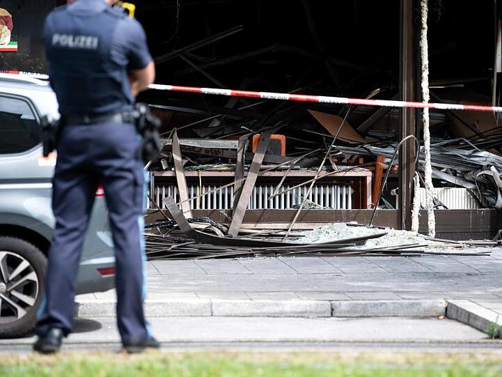 Einsatzkräfte der Polizei vor dem zerstörten Süßwarengeschäft in München. Foto: Sven Hoppe/dpa
