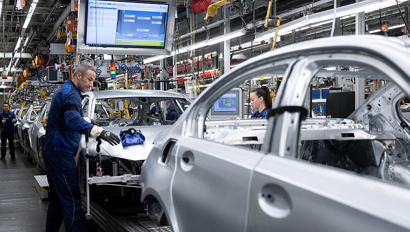 Mitarbeiter von BMW arbeiten im Stammwerk in der Produktion an der Karosserie von verschiedenen Modellen des Autoherstellers.