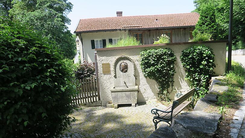 Der Brunnen mit Gedenktafel vor der Schlo&szlig;wirtschaft in Leutstetten.