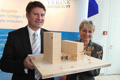 Die VR-Vorstände Dirk Helmbrecht und Brigitte Baur mit dem Modell des Bankenturms und seines sechstöckigen Anbaus.