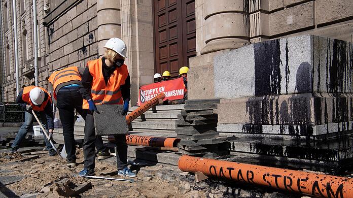 Aktivisten vom Bündnis "Letzte Generation" reißen den Gehweg vor dem Bundeswirtschaftsministerium auf, um Rohre für die symbolische Pipeline "Katar-Stream" zu verlegen.