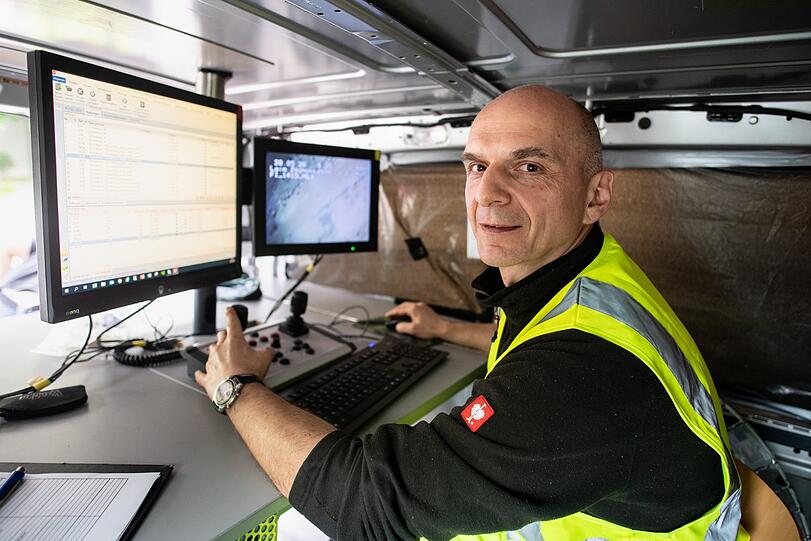Bernhard Kallweit. Ressort Mobilität bei den Stadtwerken München, sitzt vor einem Monitor, auf dem er das Kamerabild eines Kameraroboters während einer Düker-Inspektion beobachten kann