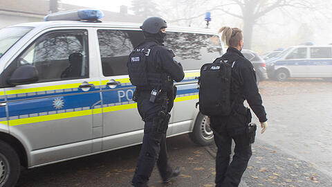 Zwei Polizisten gehen über einen Vorplatz am Bahnhof. In einem ICE zwischen Regensburg und Nürnberg hat es am Samstag eine Messerattacke gegeben. Mehrere Menschen wurden verletzt, wie die Polizei mitteilte.