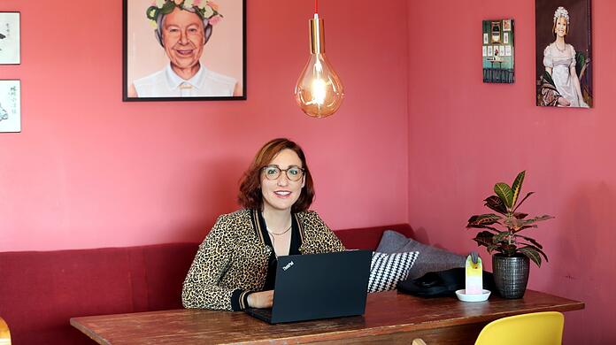 Christl Sittenauer am typischen Arbeitsplatz 2020: im Homeoffice. Von der Wand rechts grüßt eine royale Uschi Glas, links ist - ja, tatsächlich - Queen Elizabeth zu sehen