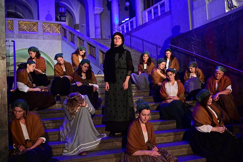 Ekaterina Isachenko (Maria, liegend) und Carolin Ritter (Ljubow) mit dem Opera Incognita Chor im Lichthof.