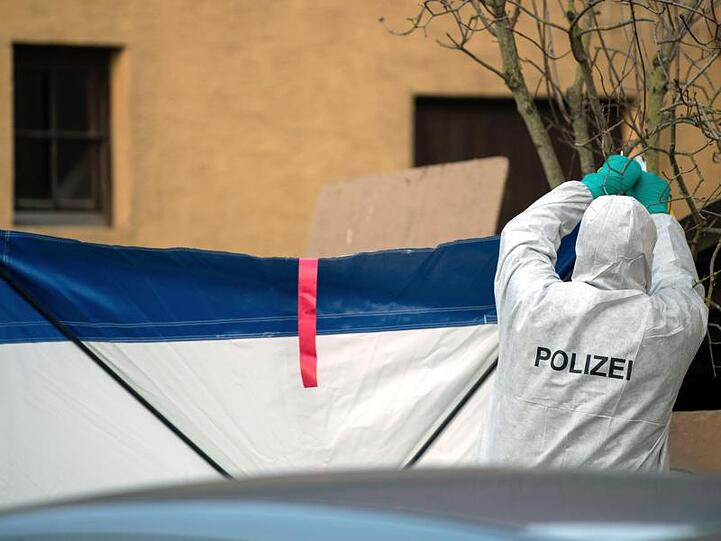 Gegen Gaffer: Nach den Schüssen in Rot am See befestigt ein Mitarbeiter der Spurensicherung einen Sichtschutz.