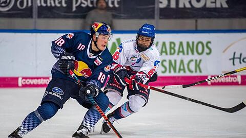 Justin Schütz von Red Bull München und Tim Stützle von Adler Mannheim (l-r.) bemühen sich um den Puck. Foto: Lino Mirgeler/dpa