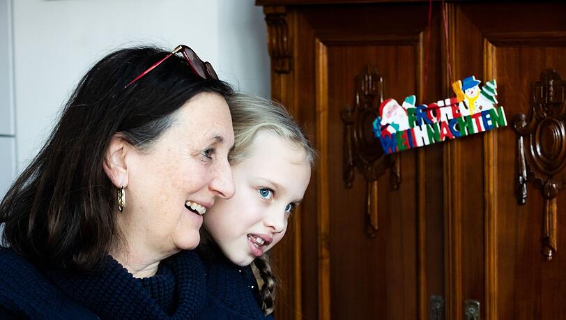 Die 6-jährige Yeva aus der Ukraine schaut in Berlin über die Schulter ihrer Gastgeberin Rosemarie.