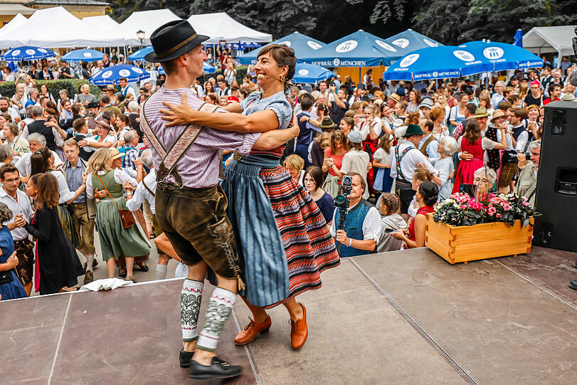 Katharina Mayer und Magnus Kaindl zeigen als Tanzmeister von der Bühne herab beim Kocherlball am Chinesischen Turm die Tanzschritte.