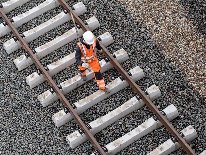 Ein Arbeiter geht über eine noch nicht fertige Gleisanlage der Bahn.