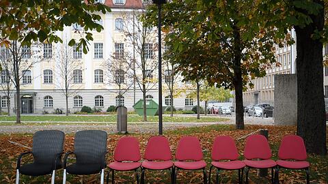 Zwei schwarz-graue uns sechs rote Stühle stehen am Rundfunkplatz aufgereiht. Dazu noch ein bisschen Geschirr. Und ein längst überfälliges Wahlplakat...