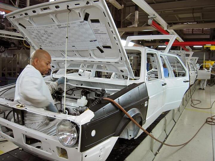 Ein Mitarbeiter montiert einen Golf Typ I im südafrikanischen VW-Werk bei Port Elizabeth. Die Fabrik wird in eine Corona-Klinik umgebaut.
