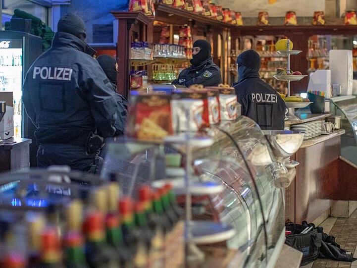 Polizisten in einem Eiscafé in Duisburg: Insgesamt sind bundesweit 65 verdächtige Objekte durchsucht worden.