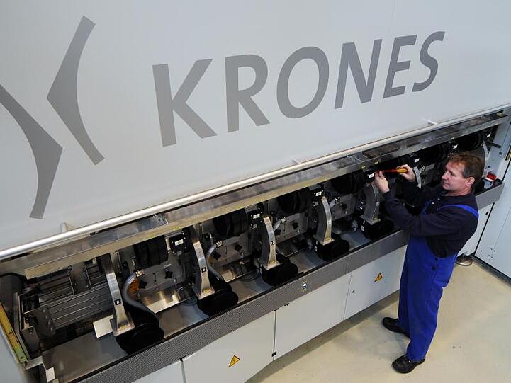 Logo der Krones AG prangt an einer Streckblasmaschine. Foto: Armin Weigel/dpa