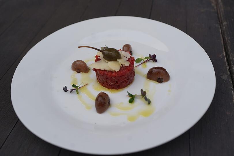 Erster Gang: Toskanisches Rindertatar mit Borettane-Zwiebeln, Kapern-Apfel, Parmesanhobeln und hausgebackenem Brot. Erster Gang: Toskanisches Rindertatar mit Borettane-Zwiebeln, Kapern-Apfel, Parmesanhobeln und hausgebackenem Brot.