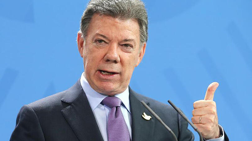 Der kolumbianische Staatspräsident Juan Manuel Santos erledigt für ein achtjähriges Mädchen die Hausaufgaben.