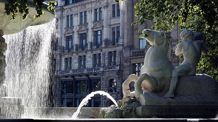 Die Schokoladenseite des Lenbachplatzes: Blick durch den Wittelsbacherbrunnen auf das prächtige Lenbach-Palais.