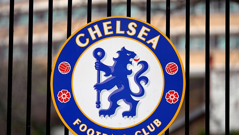 Das Logo des Fußballvereins Chelsea ist an einem Tor am Fußballstadion "Stamford Bridge" angebracht.