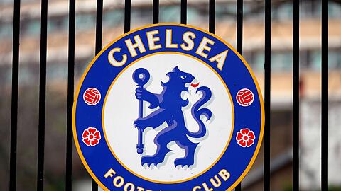 Das Logo des Fußballvereins Chelsea ist an einem Tor am Fußballstadion "Stamford Bridge" angebracht.