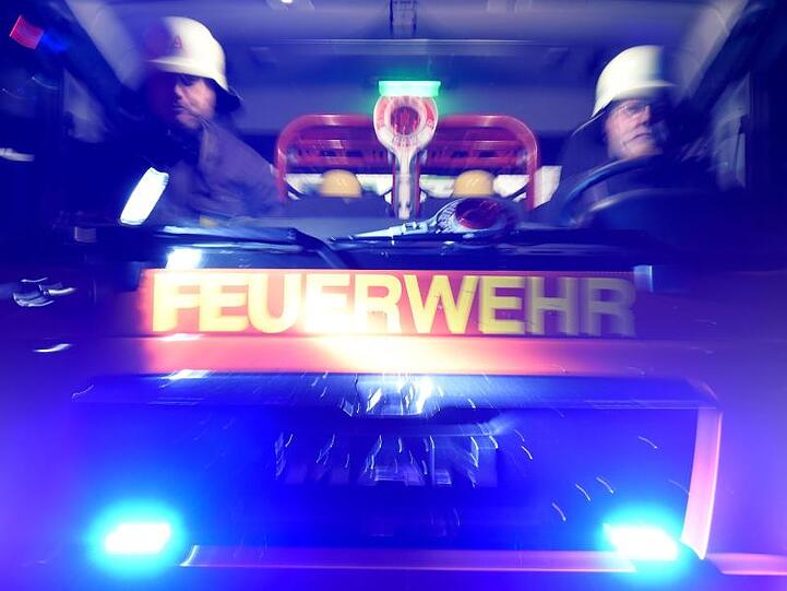 Feuerwehrmänner in einem Löschfahrzeug. Foto: Carsten Rehder/Archivbild