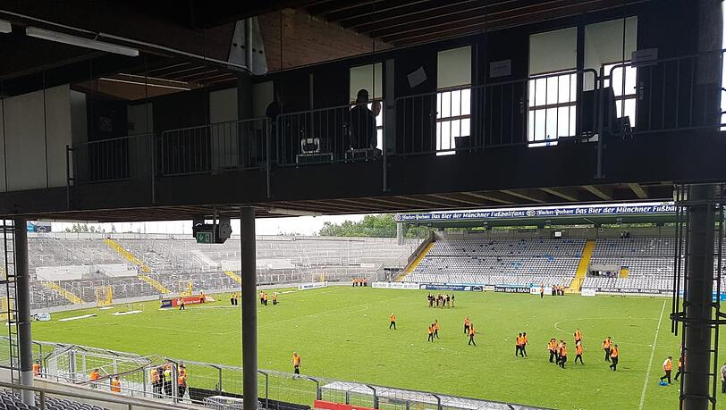 Ordner sind im sonst menschenleeren Stadion unterwegs. Der Rasen ist so löchrig, weil einige Fans sich ein Andenken mitgenommen haben. Ordner sind im sonst menschenleeren Stadion unterwegs. Der Rasen ist so löchrig, weil einige Fans sich ein Andenken mitgenommen haben.