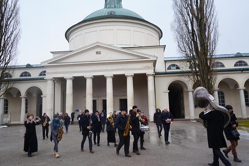 Die Trauergäste gehen aus der Aussegnungshalle zum Grab.