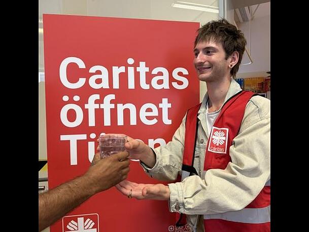 Im D3 bekommen Menschen zu Trinken und auch Kopfbedeckungen, um sich vor der Hitze zu sch&uuml;tzen.