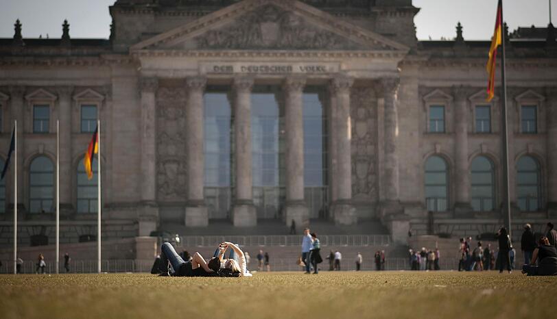 Auf der Wiese vor dem Reichstag entspannen sich die Berliner.
