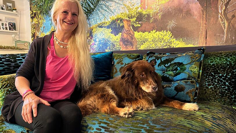 Fühlt sich freier: Christine Herrera Krebber (60) mit Familienhund Flynn vor exotischer Tapete in der neuen Wohnküche.