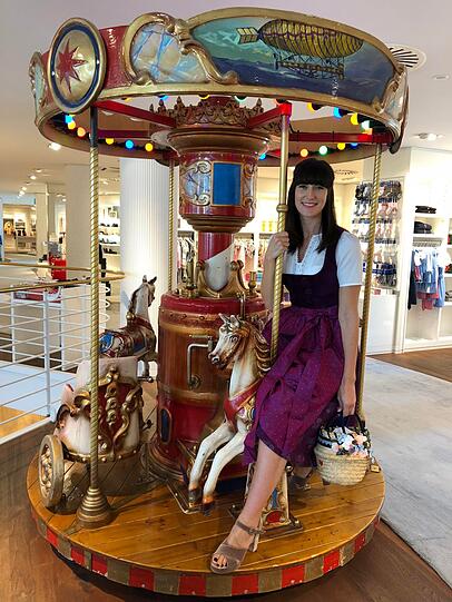 Model Cornelia Seidel trägt zum samtigen viola-farbenen Wiesn-Dirndl (449 Euro) eine angesagte Korbtasche mit Blumengesteck (159 Euro, alles Lodenfrey).