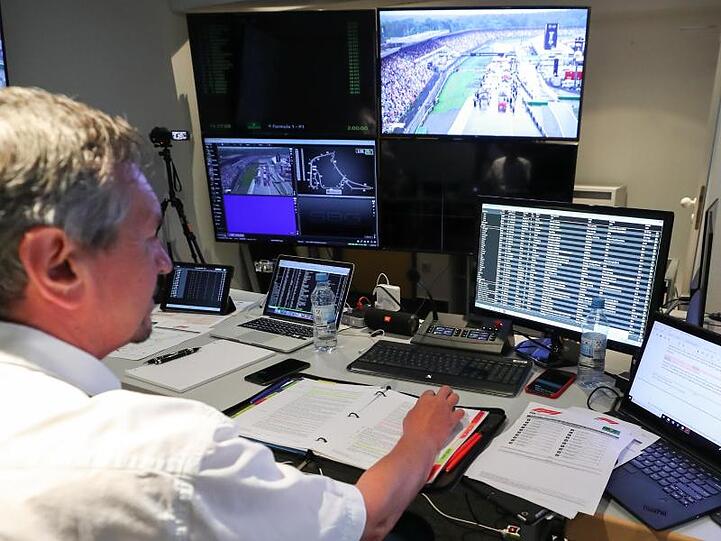 FIA-Sportkommissar Hans-Gerd Ennser sitzt an seinem Arbeitsplatz im Raum der Rennkommissare. Foto: Jan Woitas/Archivbild