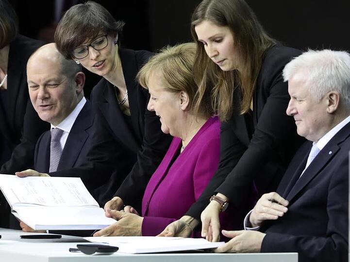 Bundeskanzlerin Angela Merkel (CDU), der CSU-Vorsitzende Horst Seehofer und der damalige, kommissarische, SPD-Vorsitzende Olaf Scholz unterzeichnen vor einem Jahr im Paul-Löbe-Haus den Koalitionsvertrag.