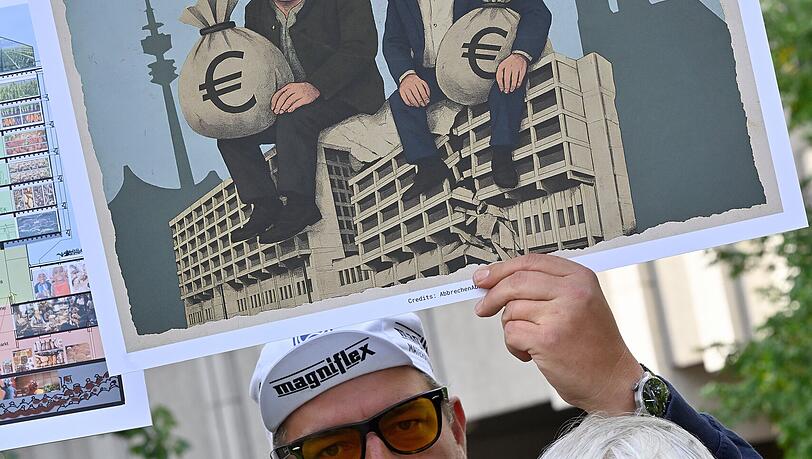 Demonstranten mit Söder-Bernreiter-Schild: "Der Freistaat saniert nur seine eigene Kasse." Demonstranten mit Söder-Bernreiter-Schild: "Der Freistaat saniert nur seine eigene Kasse."