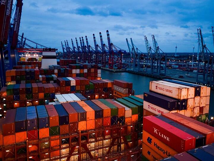 Container stapeln sich in Hamburg auf dem Deck eines Frachters. Die exportorientierte Industrie operiert angesichts globaler Handelskonflikte in schwierigem Fahrwasser.