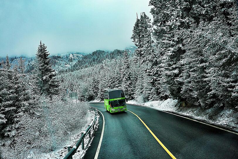 Ein Flixbus fährt durch eine winterliche Landschaft. Ein Flixbus fährt durch eine winterliche Landschaft.