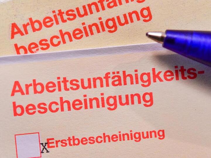 Eine Arbeitsunfähigkeitsbescheinigung liegt auf einem Tisch. Künftig soll die Krankschreibung per Videosprechstunde möglich sein.