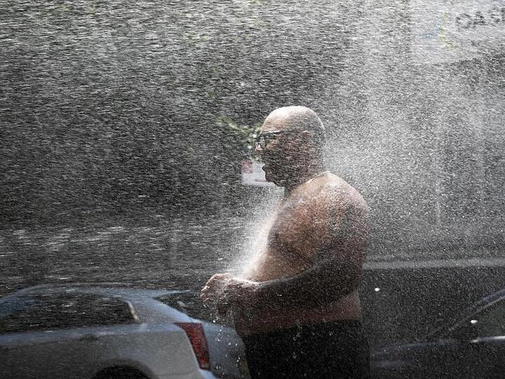 Rey Gomez kühlt sich in New York im Wasser eines Hydranten ab.
