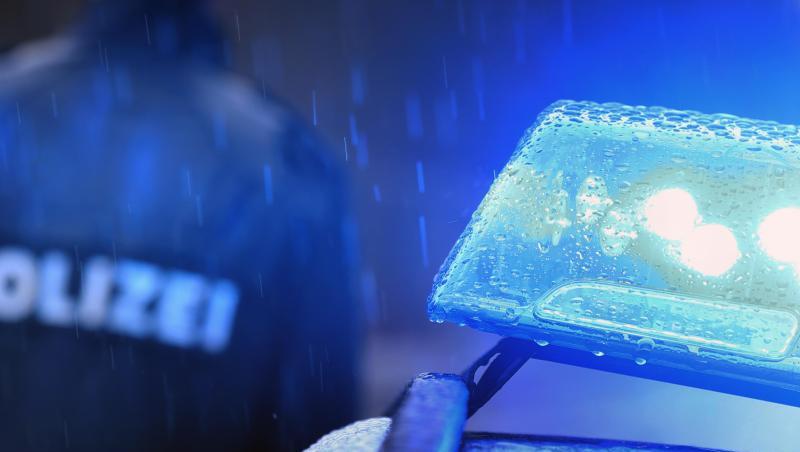 Ein Polizist steht im Regen vor einem Streifenwagen dessen Blaulicht aktiviert ist. Foto: Karl-Josef Hildenbrand/dpa/Symbolbild Ein Polizist steht im Regen vor einem Streifenwagen dessen Blaulicht aktiviert ist. Foto: Karl-Josef Hildenbrand/dpa/Symbolbild