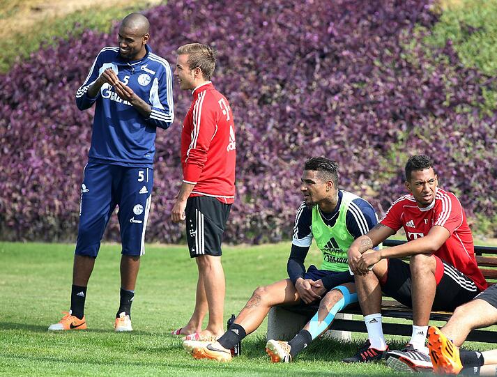 Von Bruder zu Bruder: Kevin-Prince (l.) und Jérome Boateng unterhalten sich am Rande des Schalker Trainings in Doha. Links unterhalten sich Santana und Götze. Foto: firo