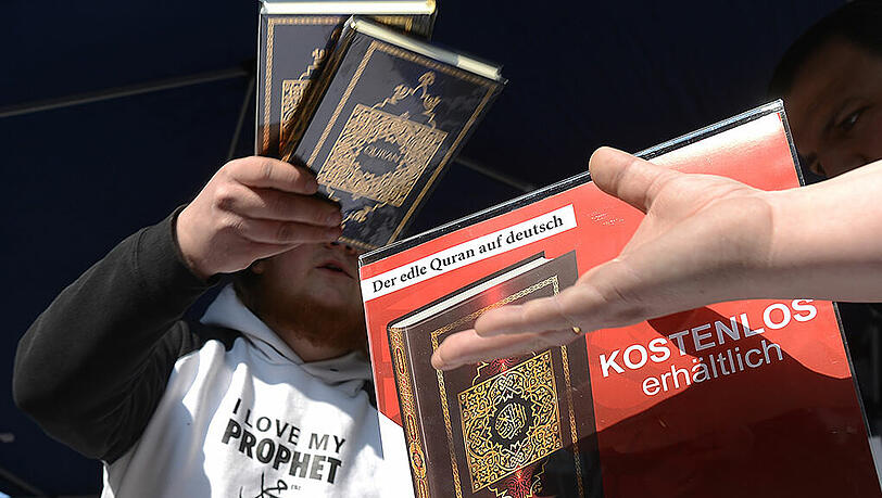 Ein Islamist verteilt kostenlose Koran-Exemplare an Passanten (Symbolbild). Ein Islamist verteilt kostenlose Koran-Exemplare an Passanten (Symbolbild).