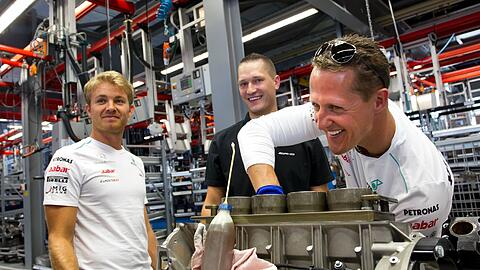 Legten mal selbst Hand an: Michael Schumacher und Nico Rosberg beim Besuch im Mercedes-AMG-Werk.
