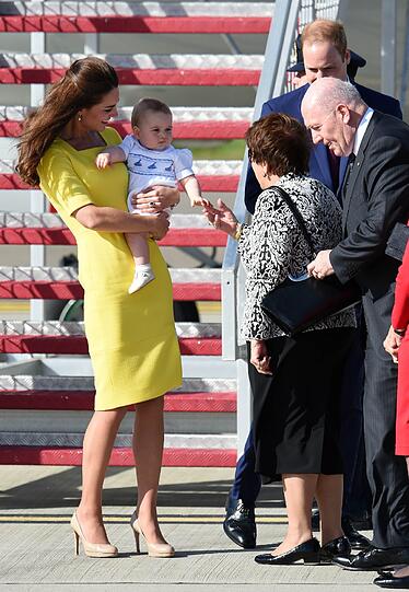 Zum Auftakt in Australien stieg Kate ganz in Gelb aus dem Flieger. Auch Baby George kann schon königlich die Hände schütteln.