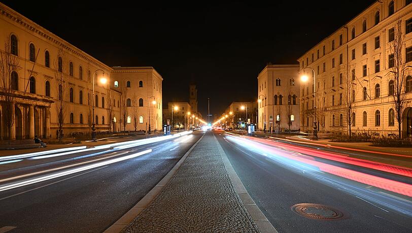 Lichtstreifen von Autoscheinwerfern sind auf der beleuchteten Ludwigsstraße in München zu sehen. (Archivbild)